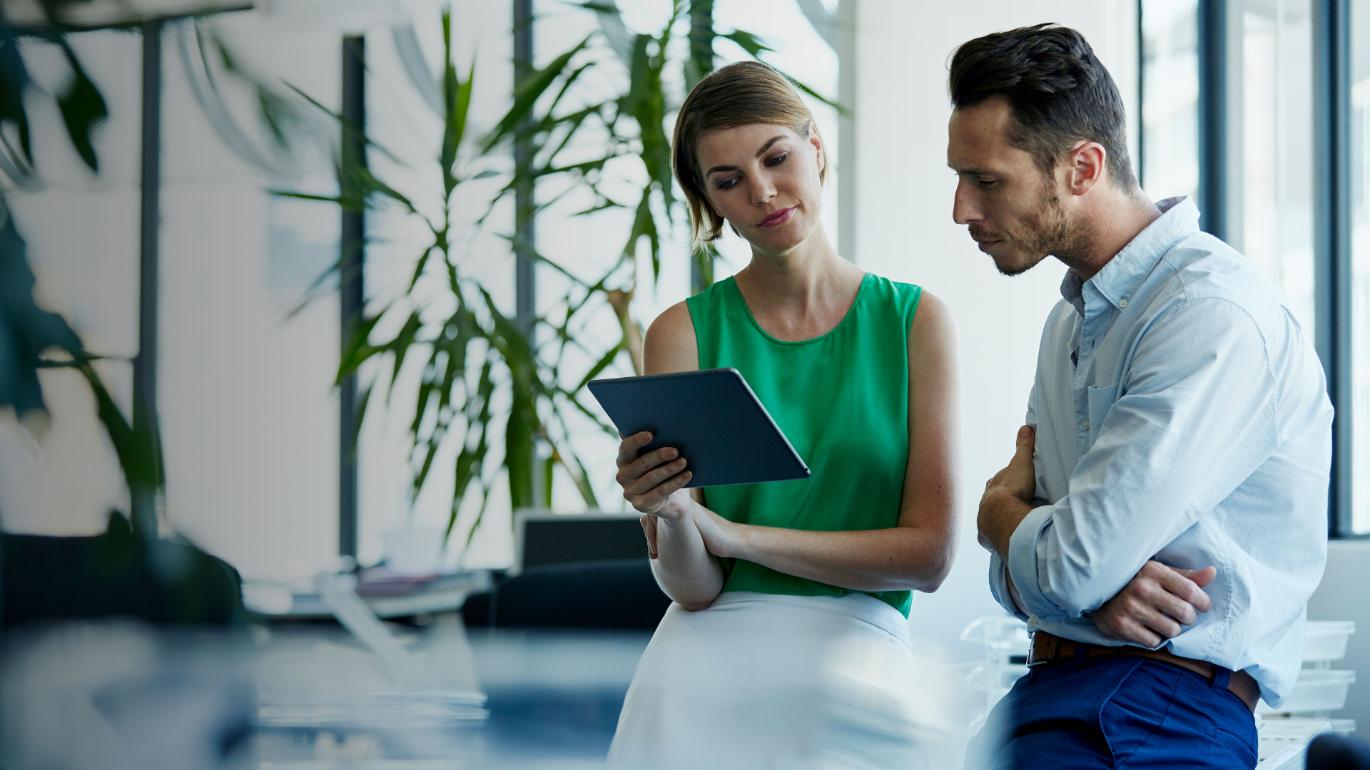 Two colleagues reviewing a tablet